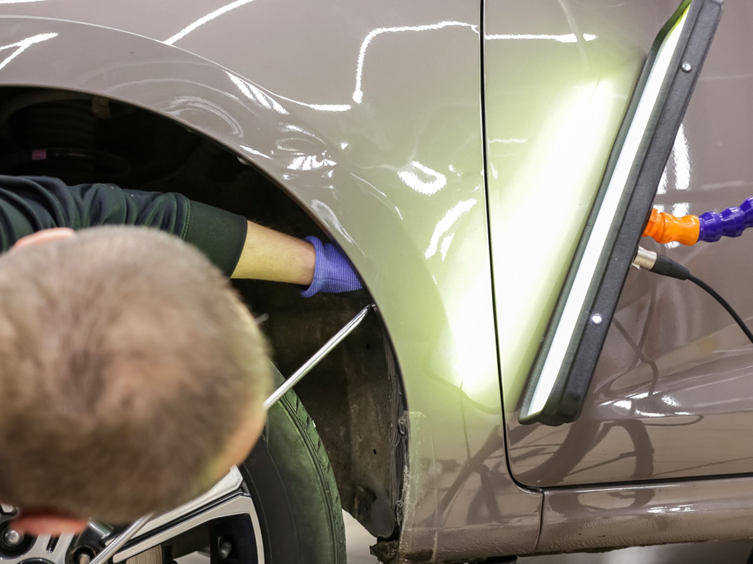 An image of a dent being mended on a car.