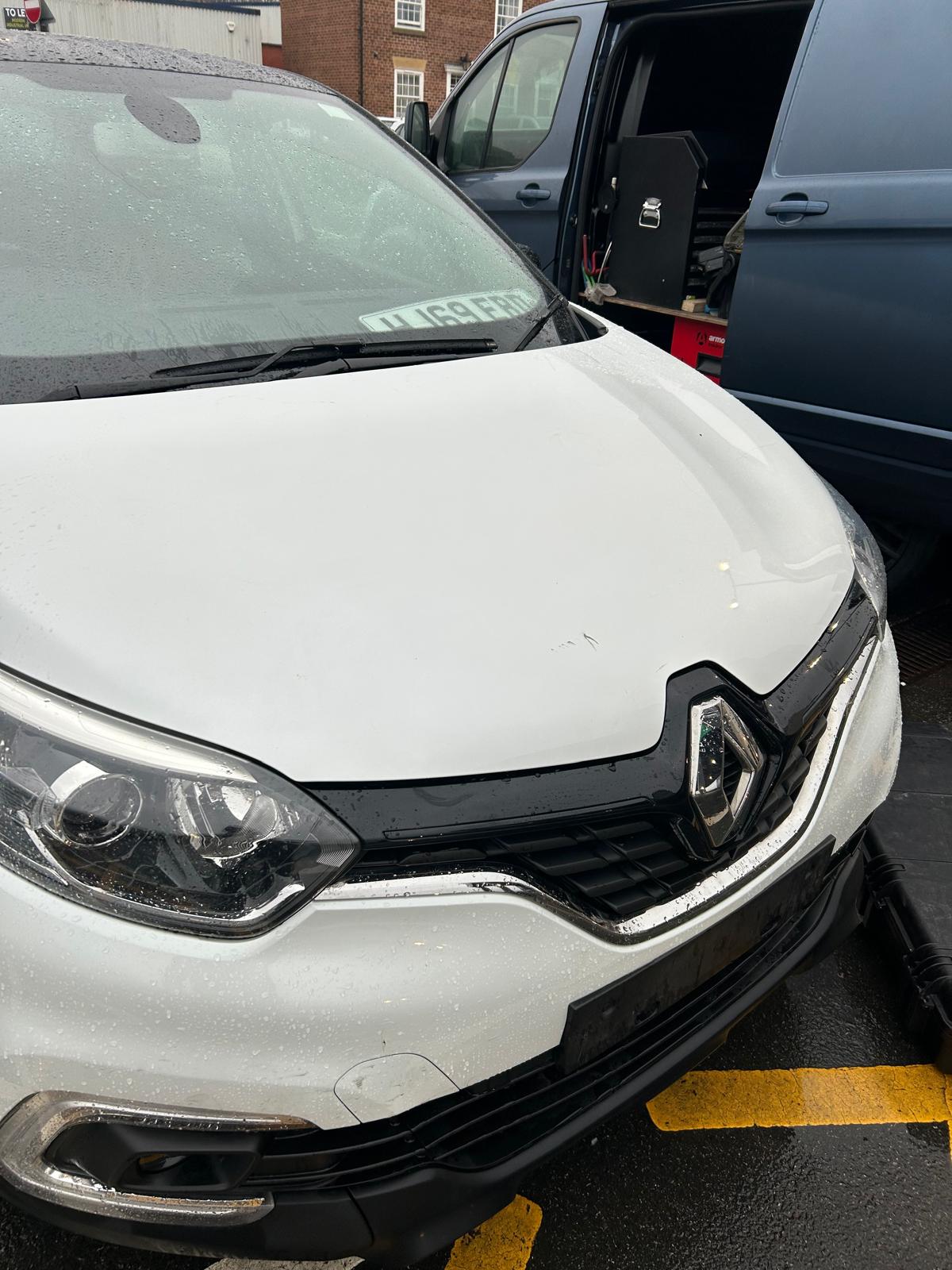 The dent on the white Renault is fixed.