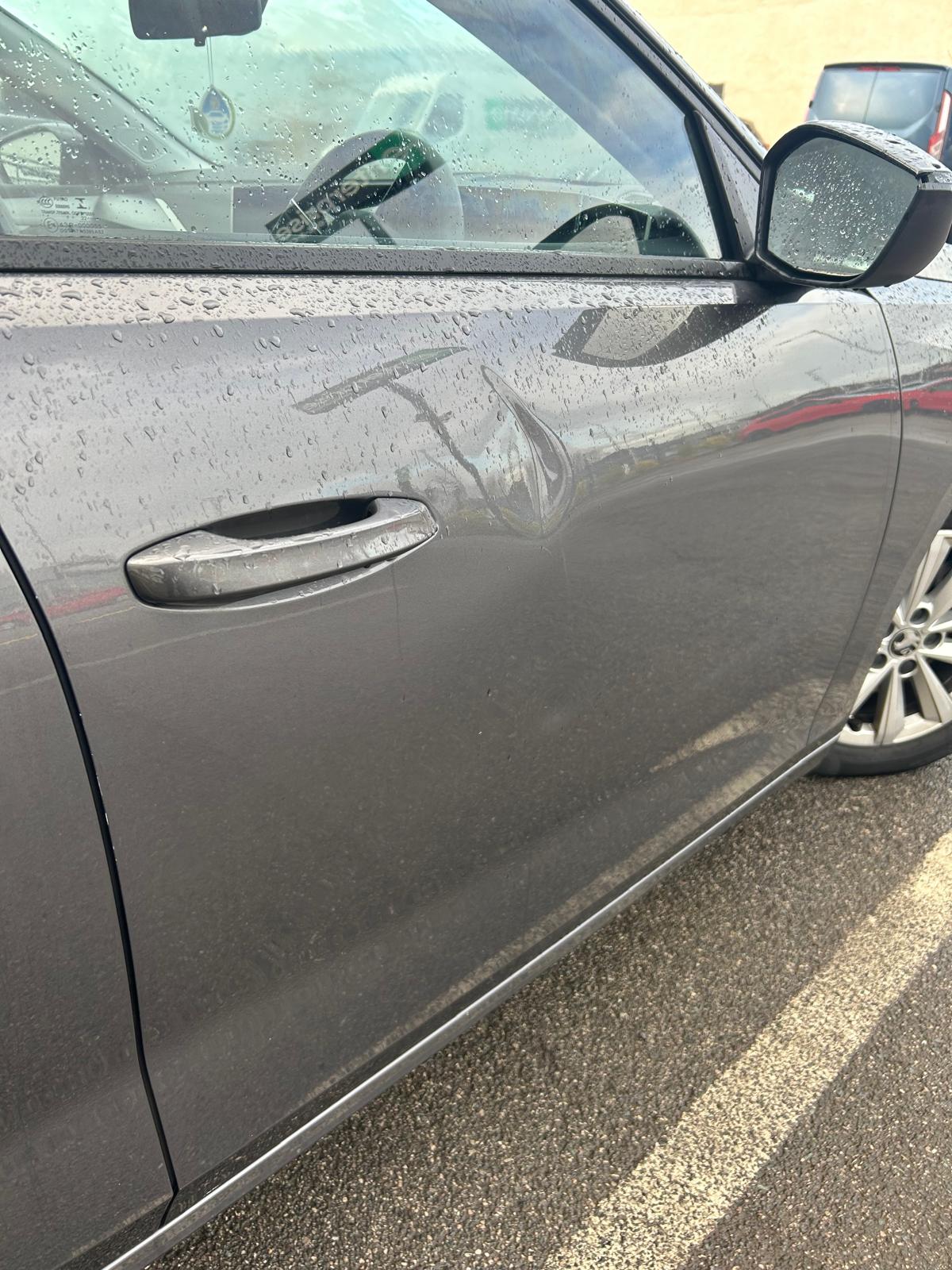 A dent in a silver Mercedes-Benz.