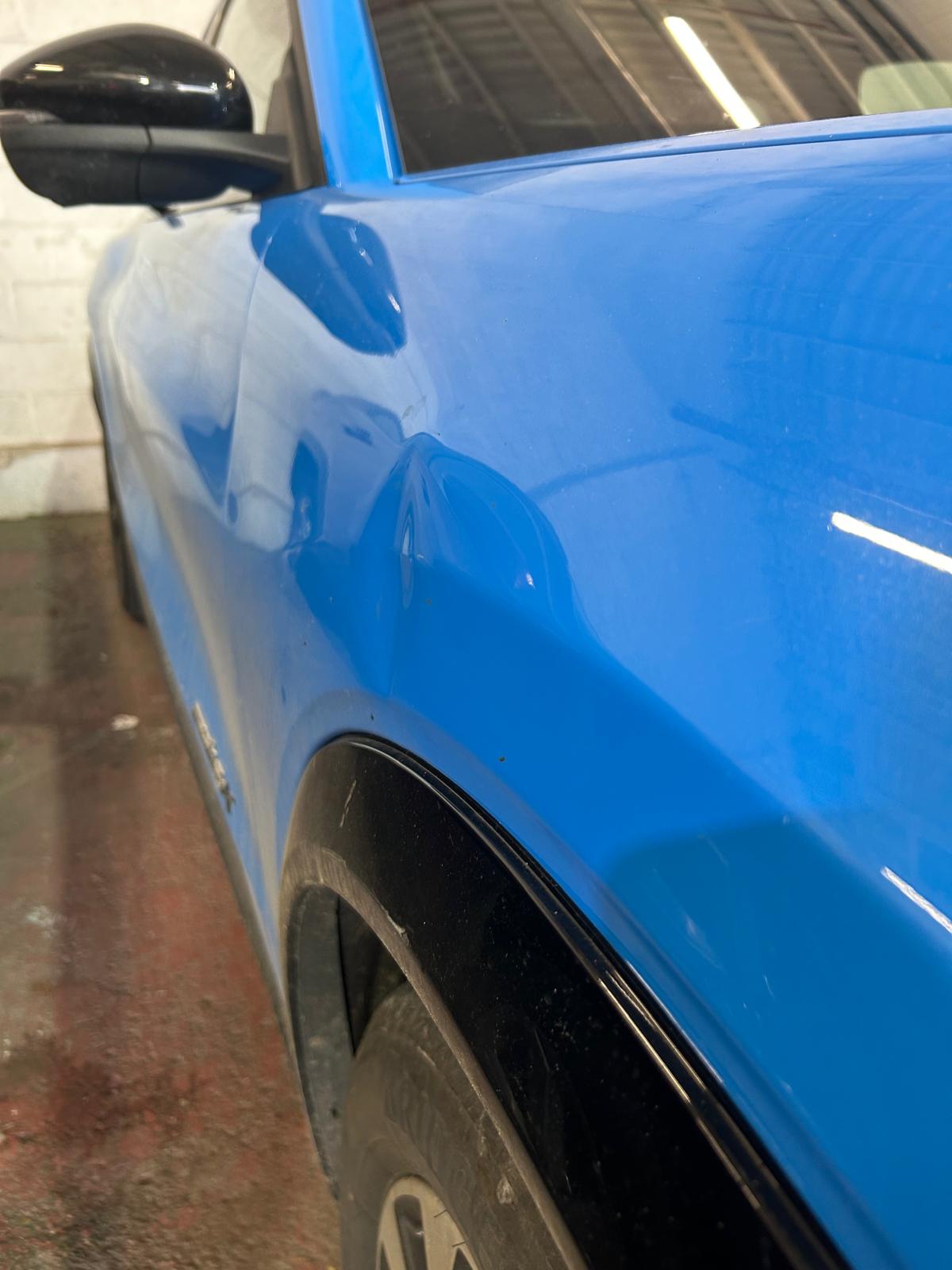 A dent on a royal blue car.