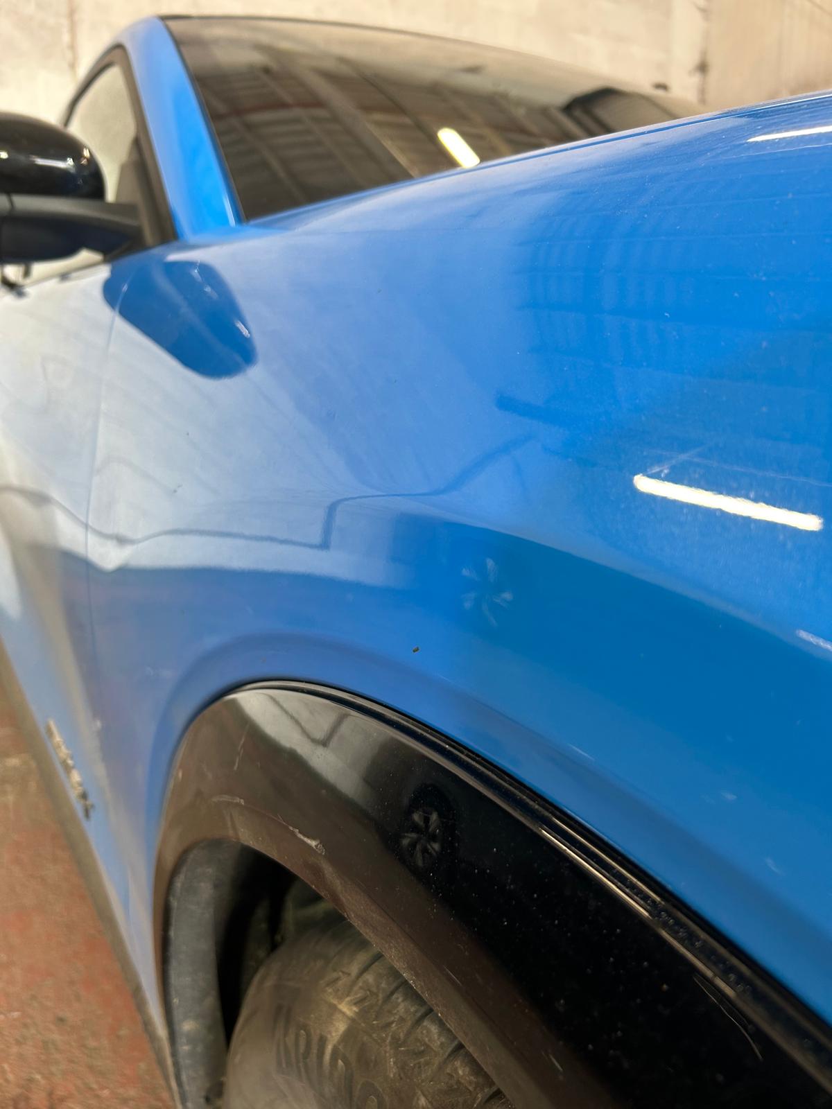 The dent on the royal blue car is fixed.