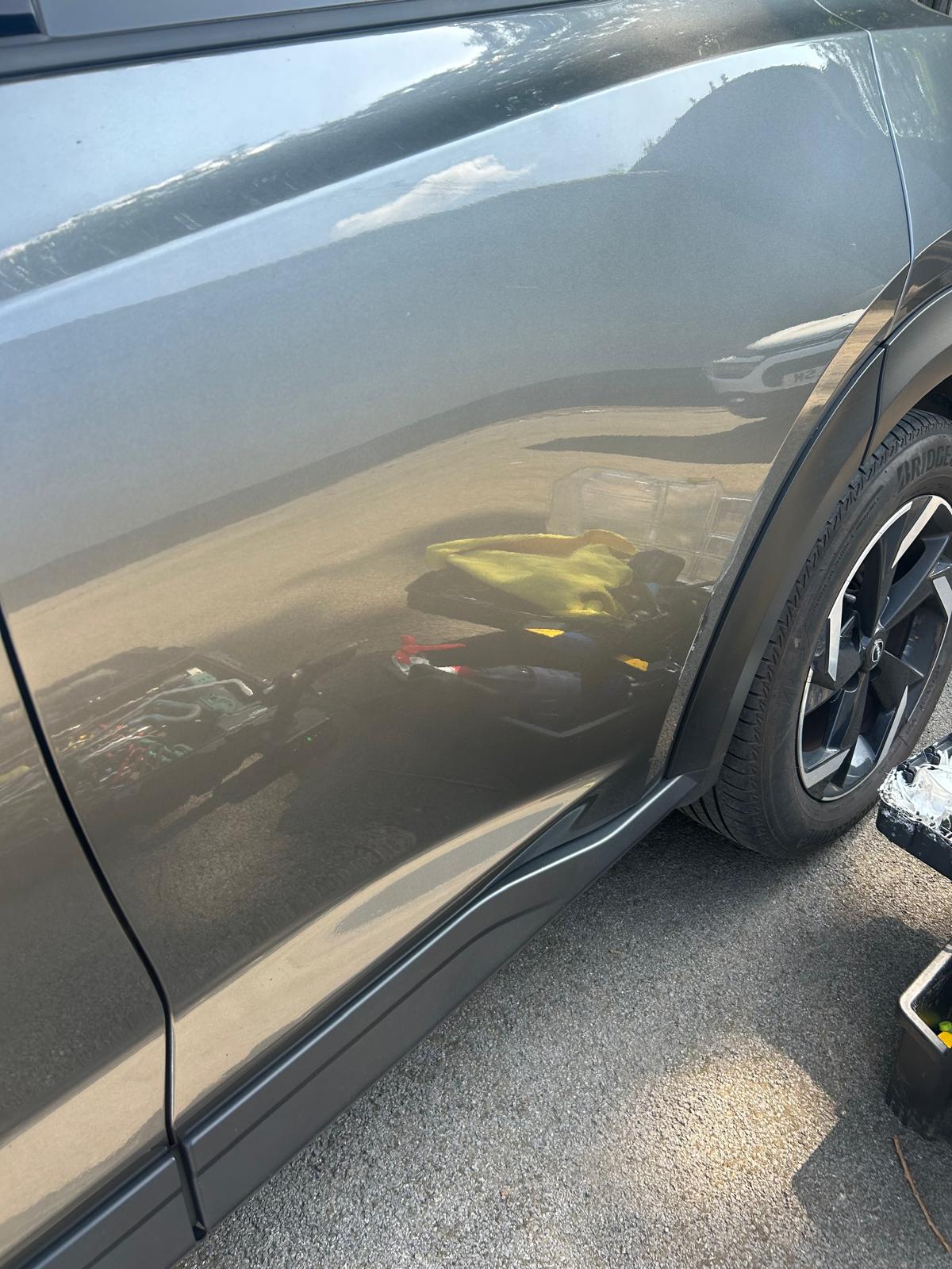 The dent on the grey Nissan is fixed.